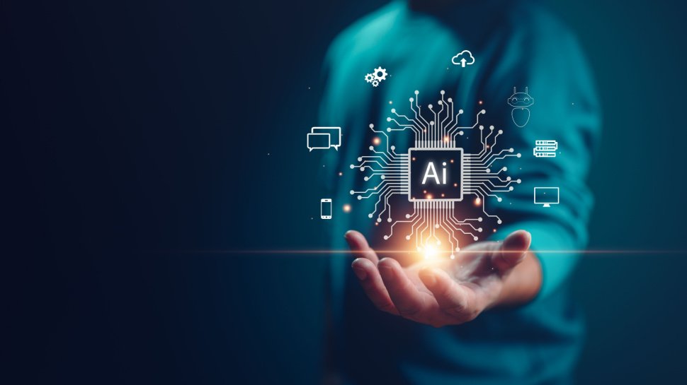 "Person's hand holding a glowing microchip with 'AI' in the center, surrounded by various icons representing technology and artificial intelligence, against a dark blue background."