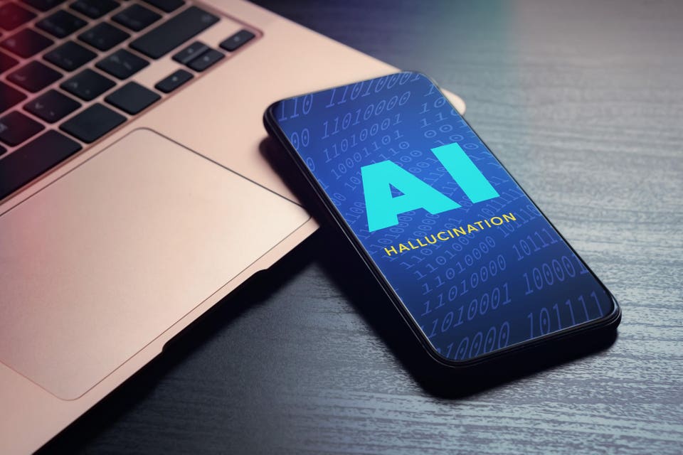 A smartphone with a blue screen displaying large blue letters "AI" and smaller yellow text "HALLUCINATION" over binary code, resting next to a rose gold laptop.