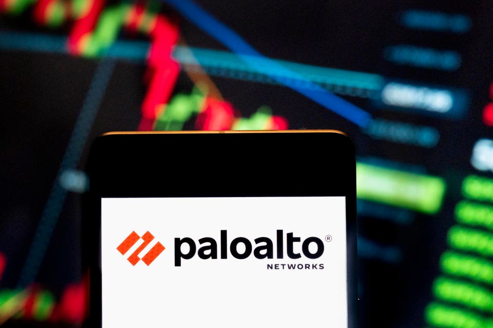 Palo Alto Networks logo displayed on a smartphone screen, with blurred stock charts in the background.