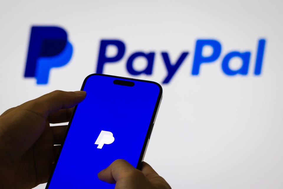 "Smartphone displaying the PayPal app logo, with the PayPal company name blurred in the background."