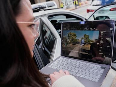Person in glasses looking at a laptop screen displaying an outdoor street view, with a white car in the background.